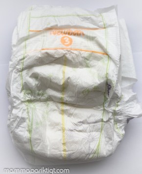 Newborn med färgindikator för blöjbyte